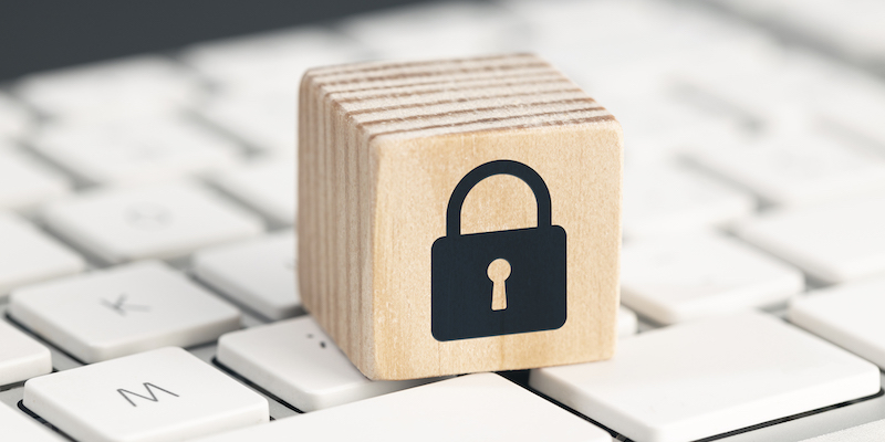 Computer Security protection concept. Cyber attack protection. Closed padlock icon on wooden block on computer keyboard